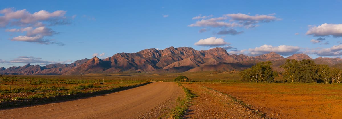 Wilpena Pound glowing red at sunset, seen across plains from the Moralana Scenic Drive
