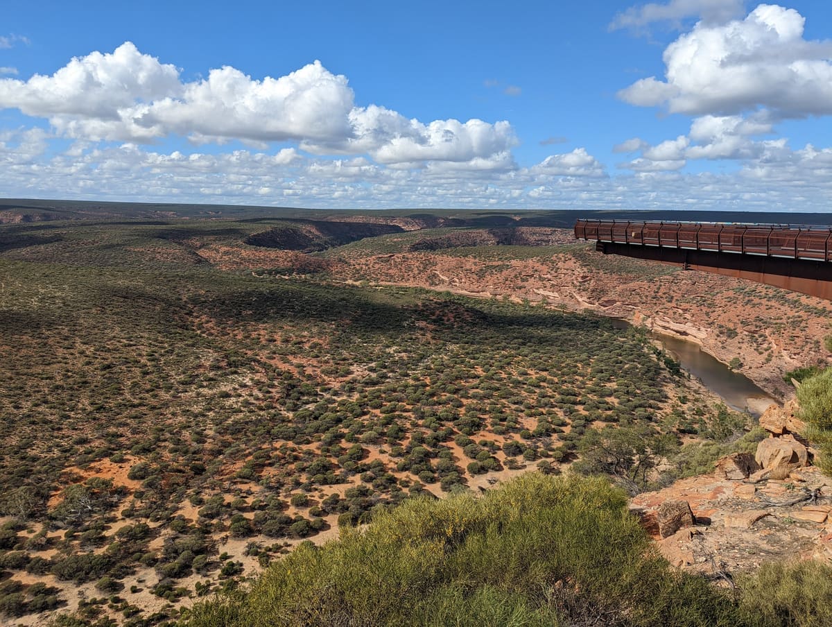 Wide panorama of the Murchison Gorge with the Skywalk platform on the rim, scrubland and cloudy sky