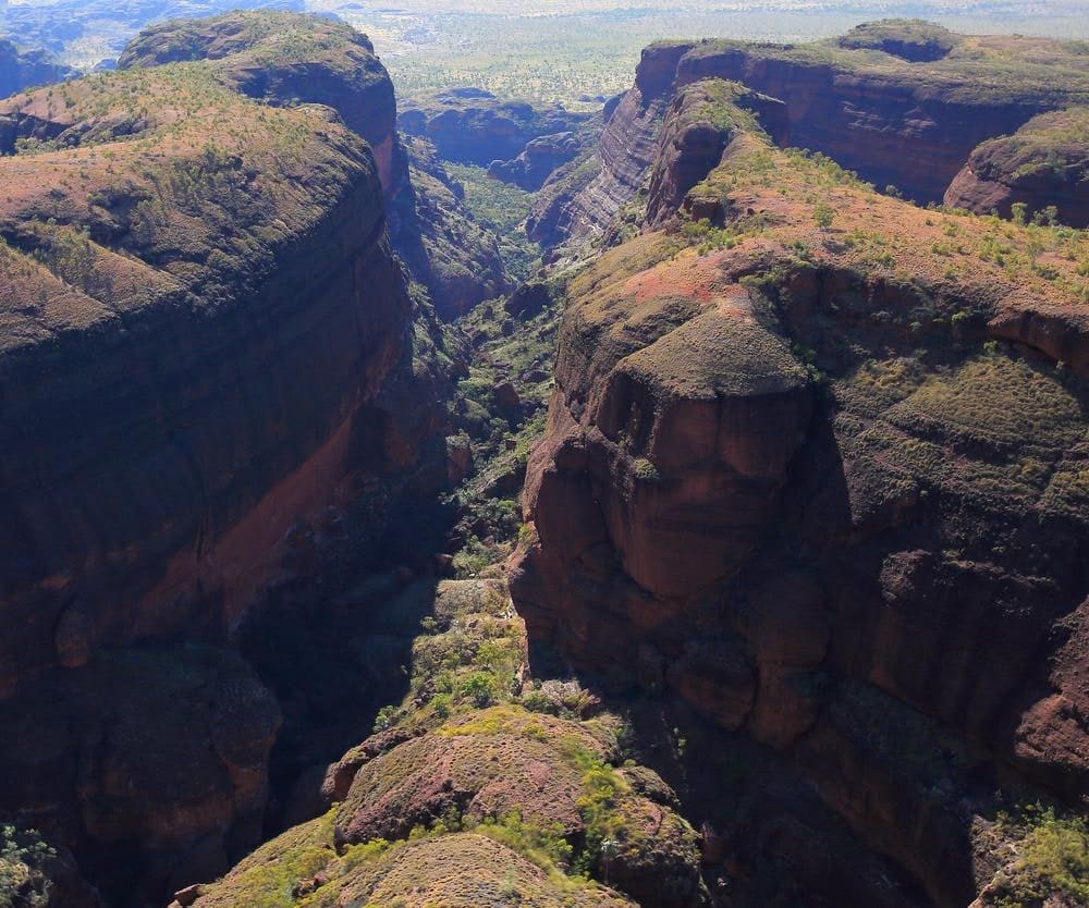 Aerial view of a red gorge cutting through the striped sandstone dome field of the Bungle Bungle Range in Purnululu National Park