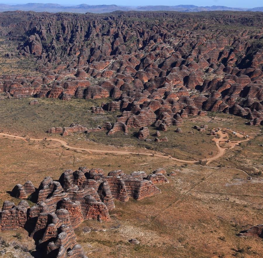 Vehicles parked at the Walardi Campground access area, the dusty trailhead for Cathedral Gorge and the Domes Trail in Purnululu National Park