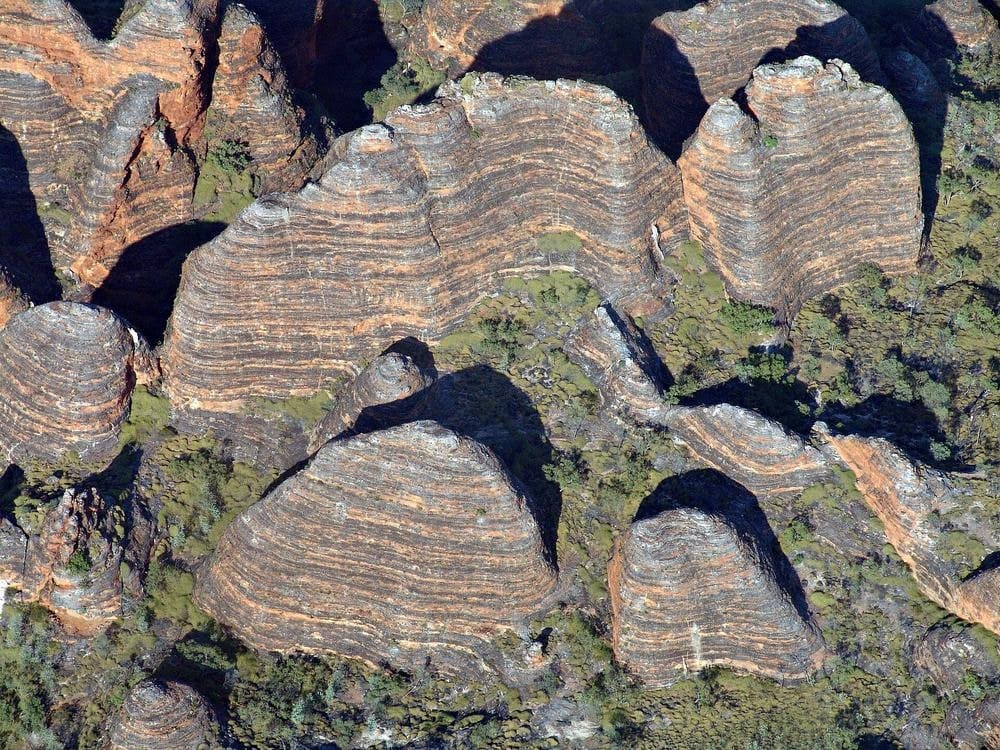 Wide ground-level view across the Bungle Bungle Range's dome formations stretching to the horizon under an East Kimberley sky