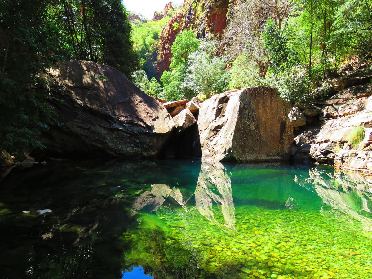 Clear green swimming hole beneath red cliffs at Emma Gorge, the Kimberley, Western Australia