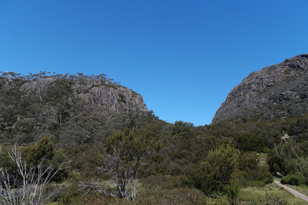 Gap between two steep dolerite crags with scrub and a faint track
