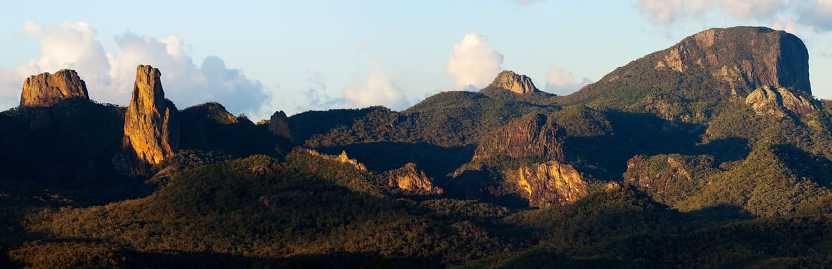 Crater Bluff, Belougery Spire, the Breadknife and Bluff Mountain over forested ranges in golden light